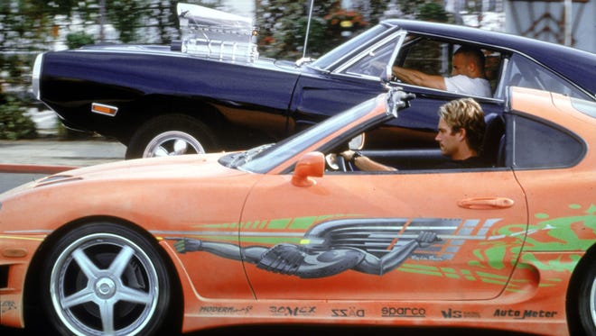 Motorworks Brewing presents Fast and the Furious movie screen shot with orange Supra and Challenger are taking off