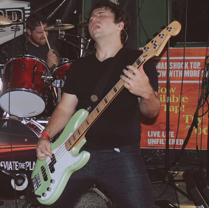 Motorworks Brewing presents Deviate the Plan band on stage with lead singer playing guitar